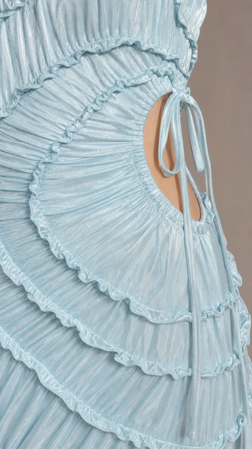 Close-up detail of cascading ruffles and side cut-out tie on light blue dress
