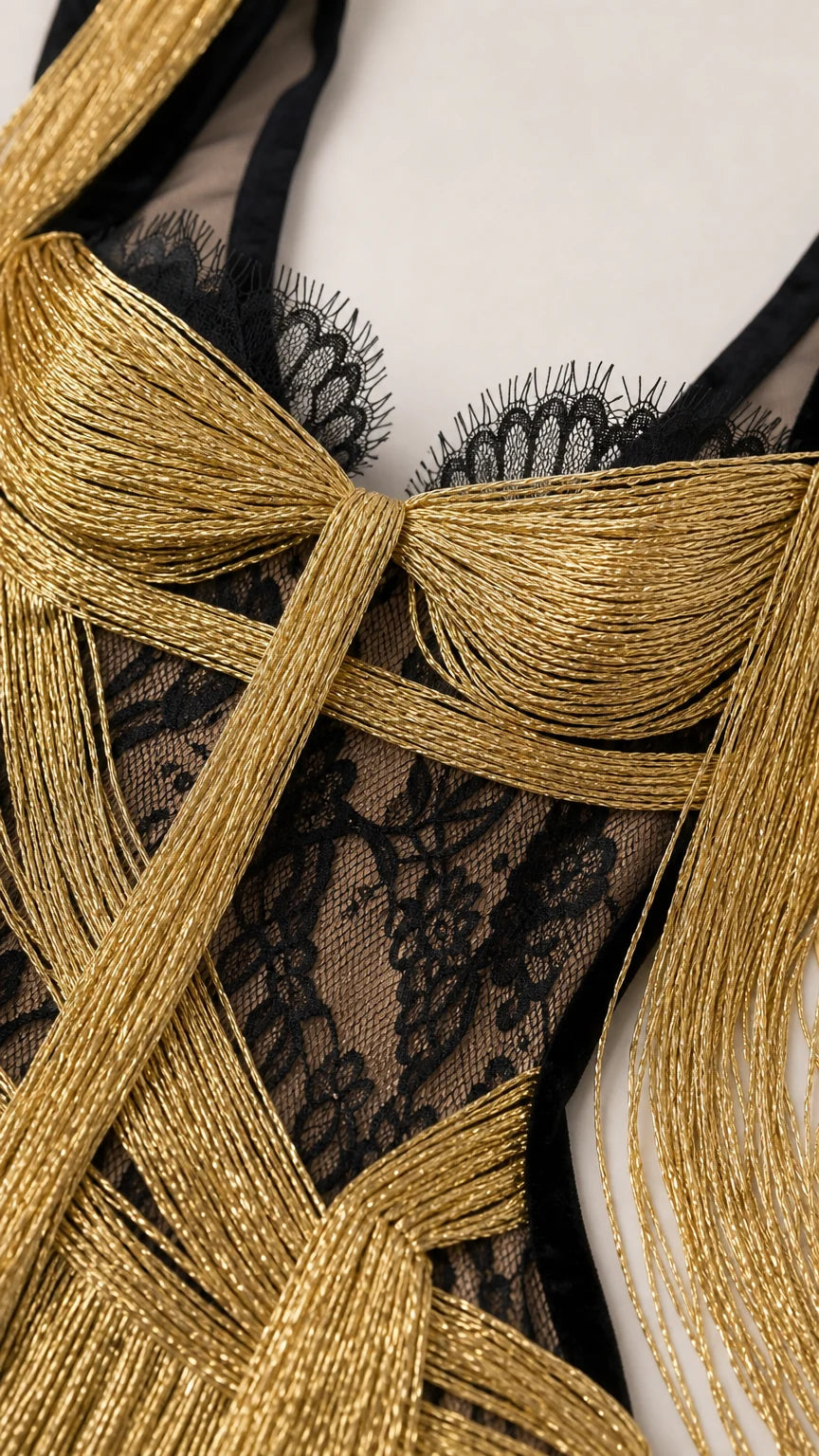 Close-up detail of gold metallic fringe and black lace bodice