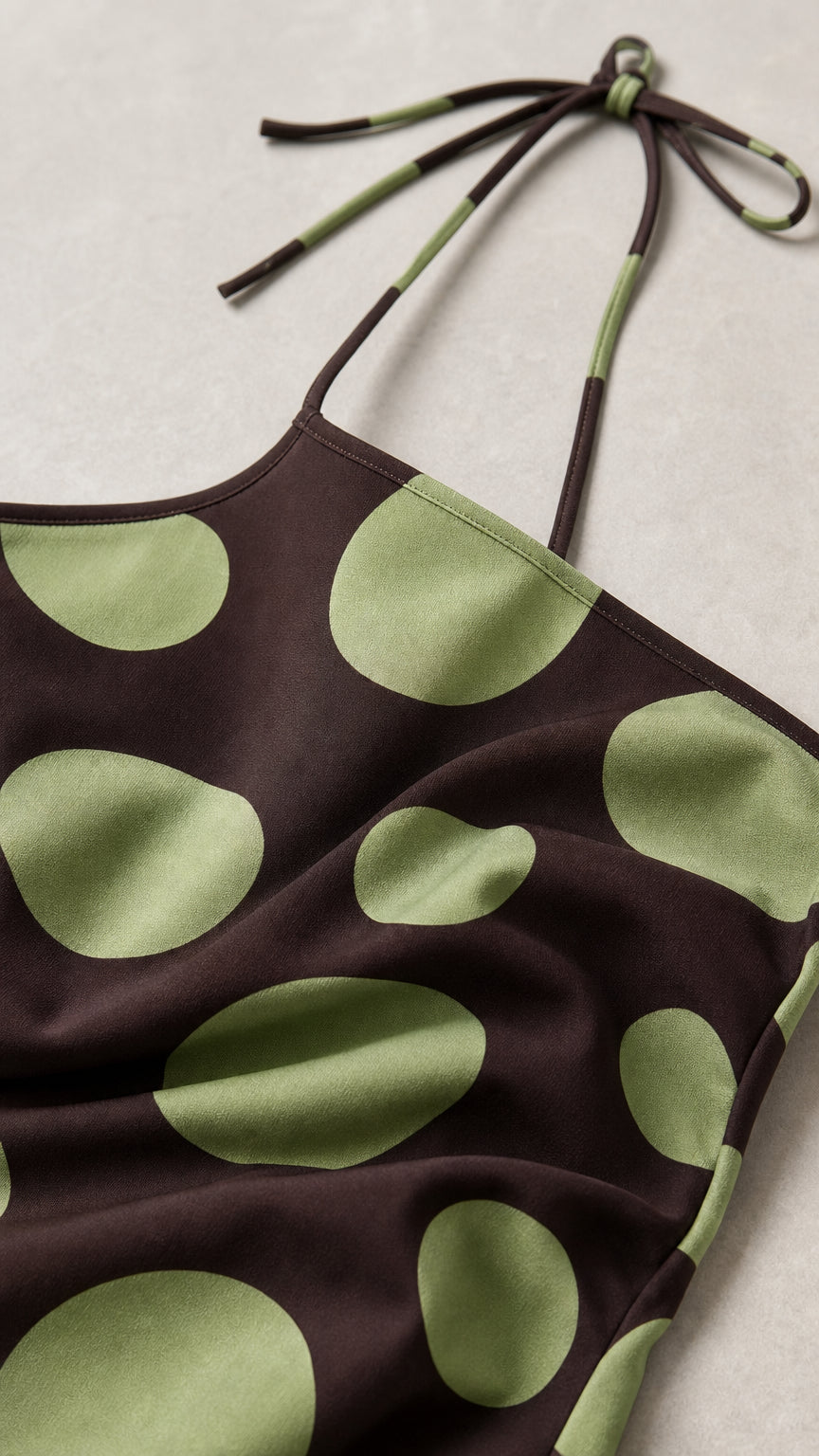Close-up detail of halter neckline and polka dot fabric