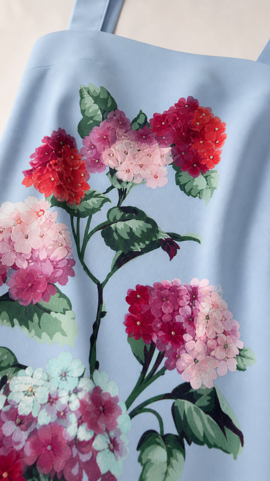 Close-up of vibrant red floral embroidery on Light Blue fabric