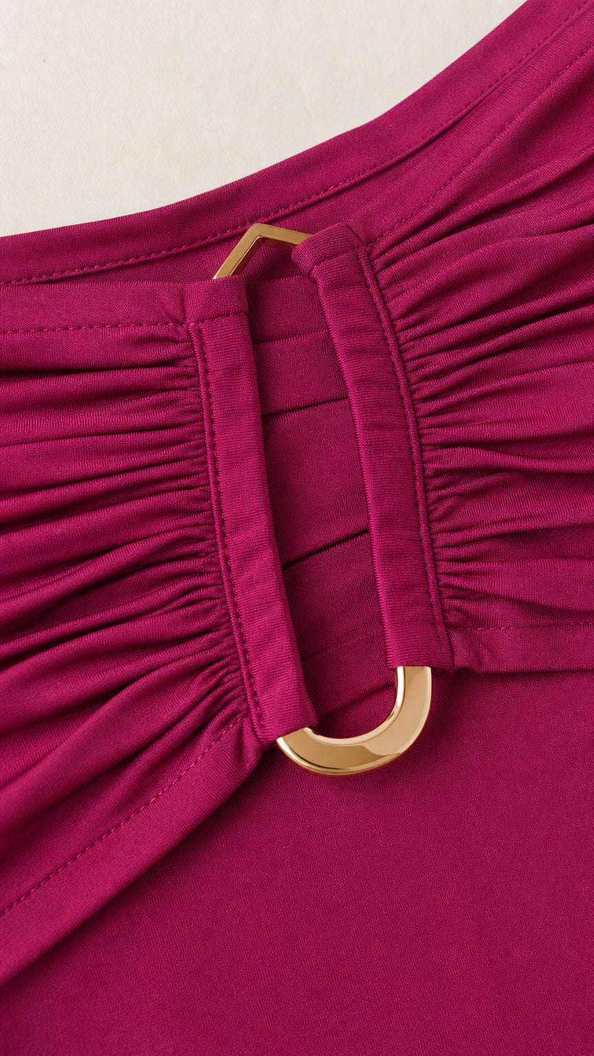 Close-up of gold-tone metal ring detail on fuchsia skirt waistband
