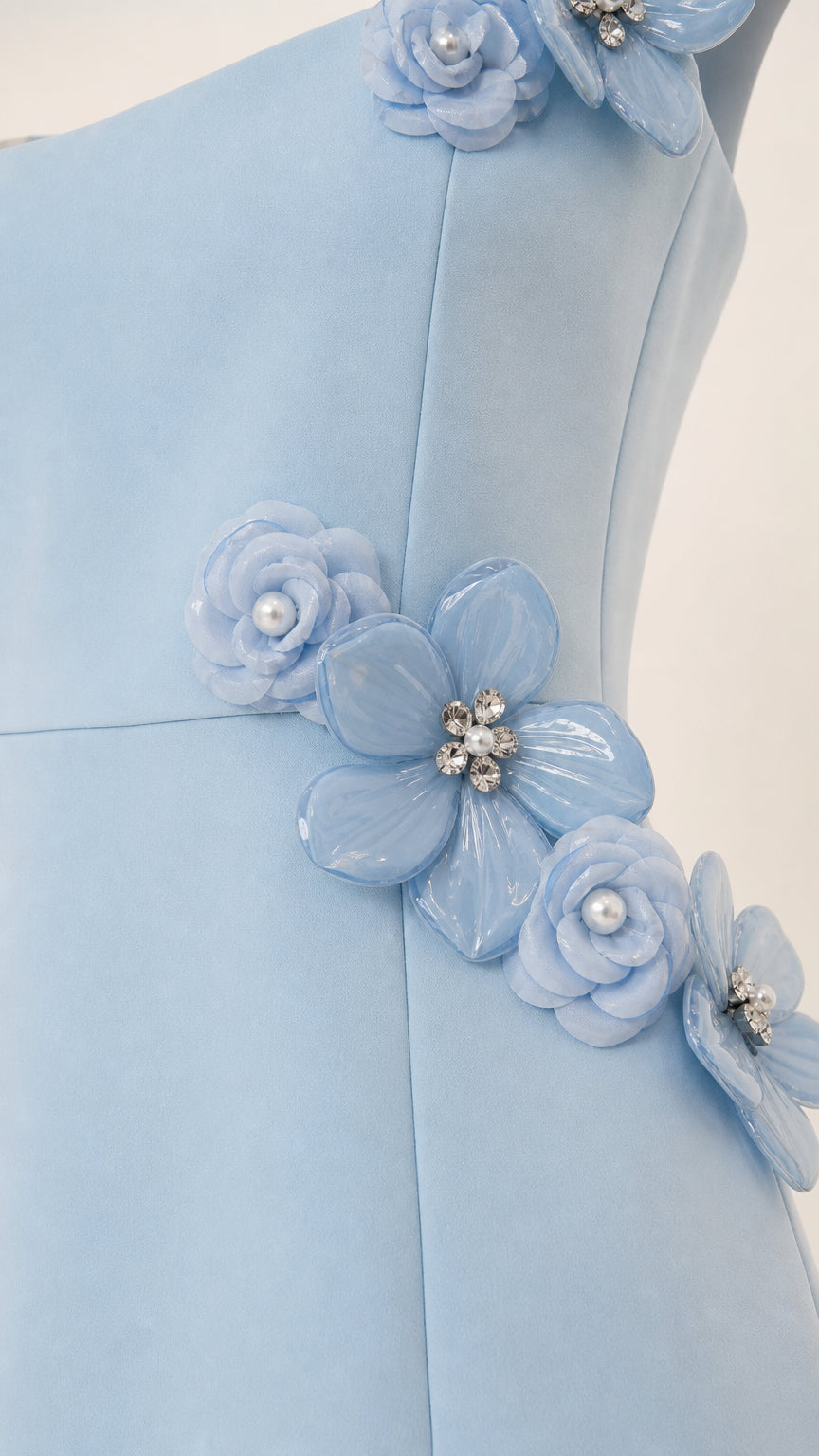 Close-up detail of 3D floral appliques on light blue dress