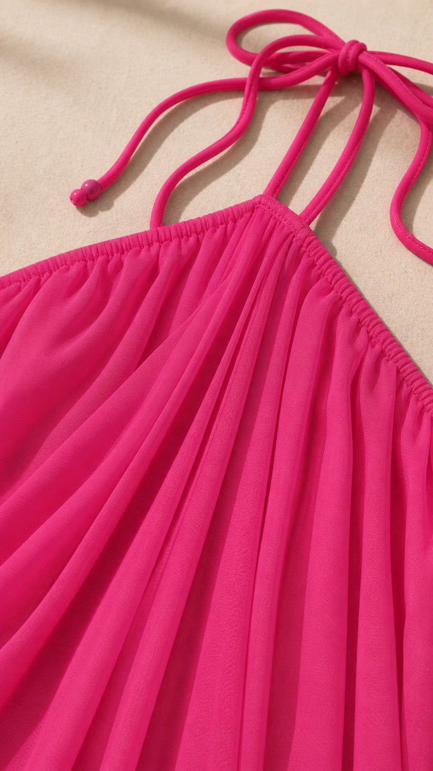 Close-up detail of the pink halter neckline and gathered fabric