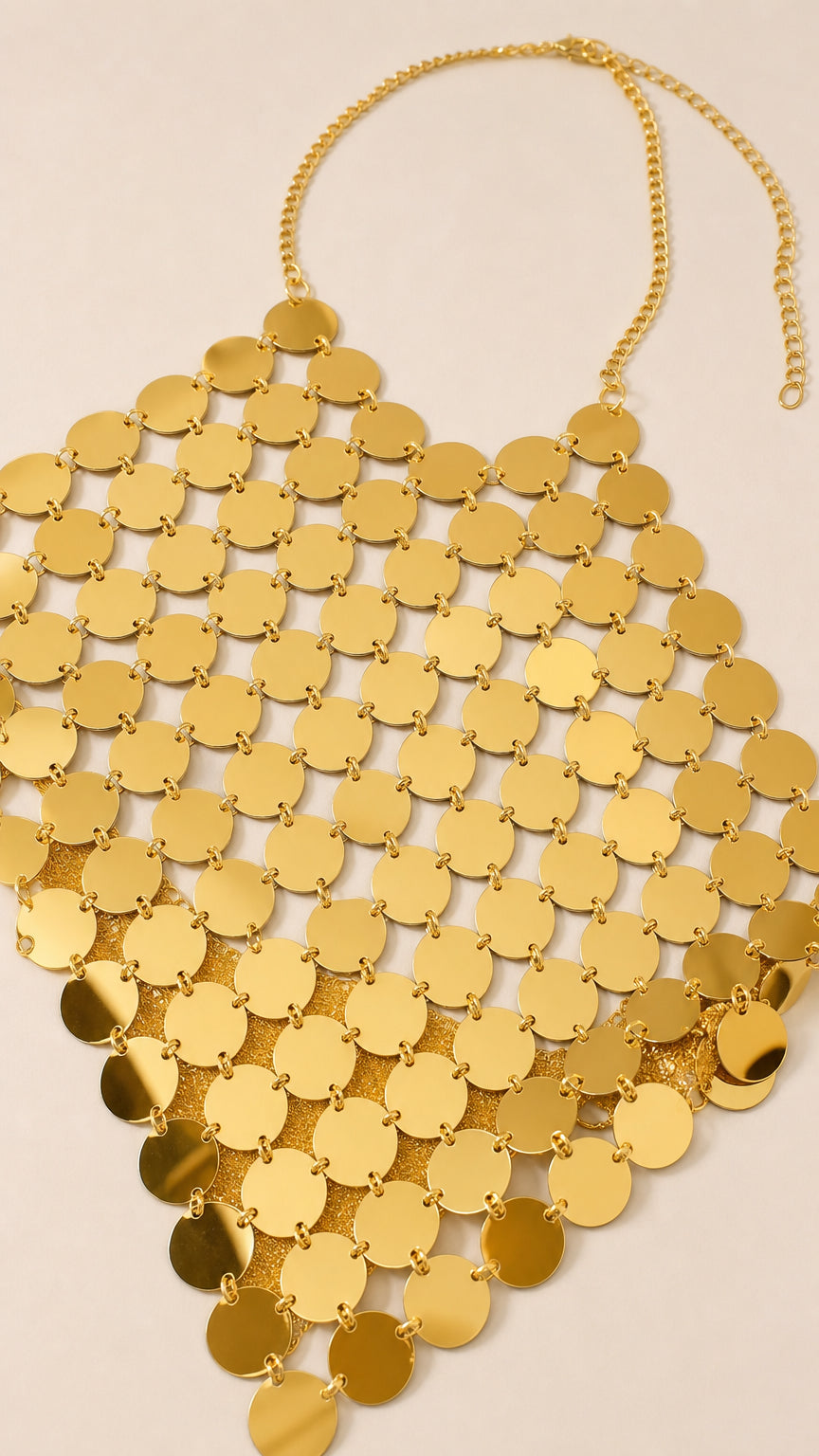 Close-up flat lay of the gold metallic disc halter top