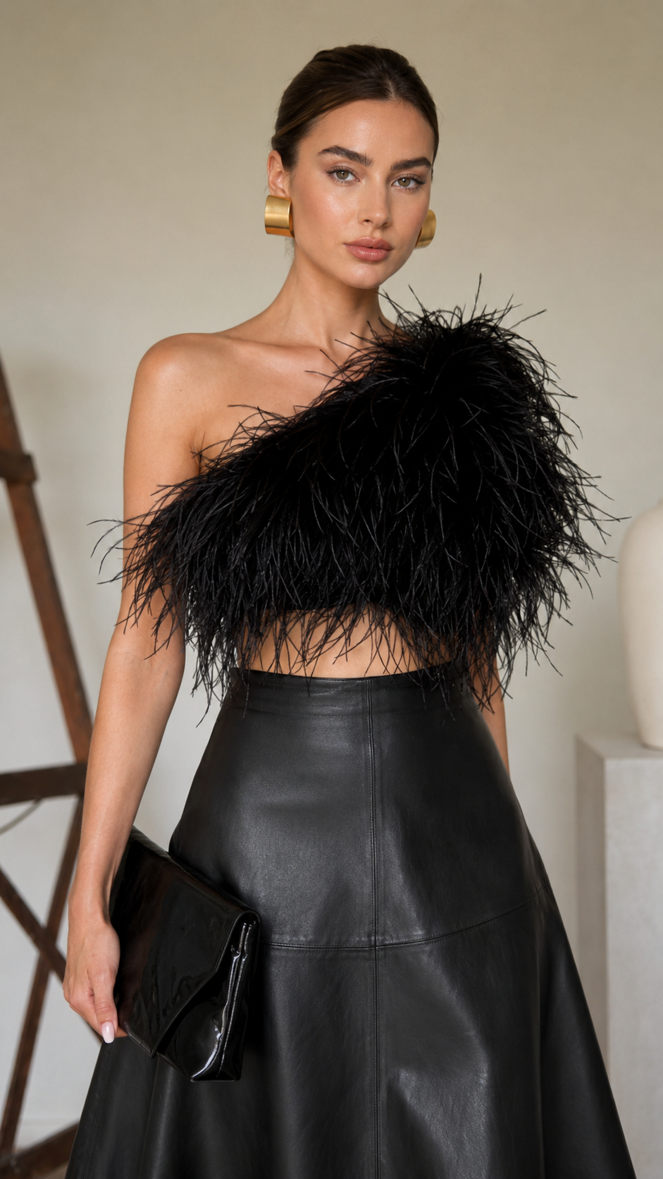 Close-up of the black faux leather A-line midi skirt showing the high waist and smooth finish