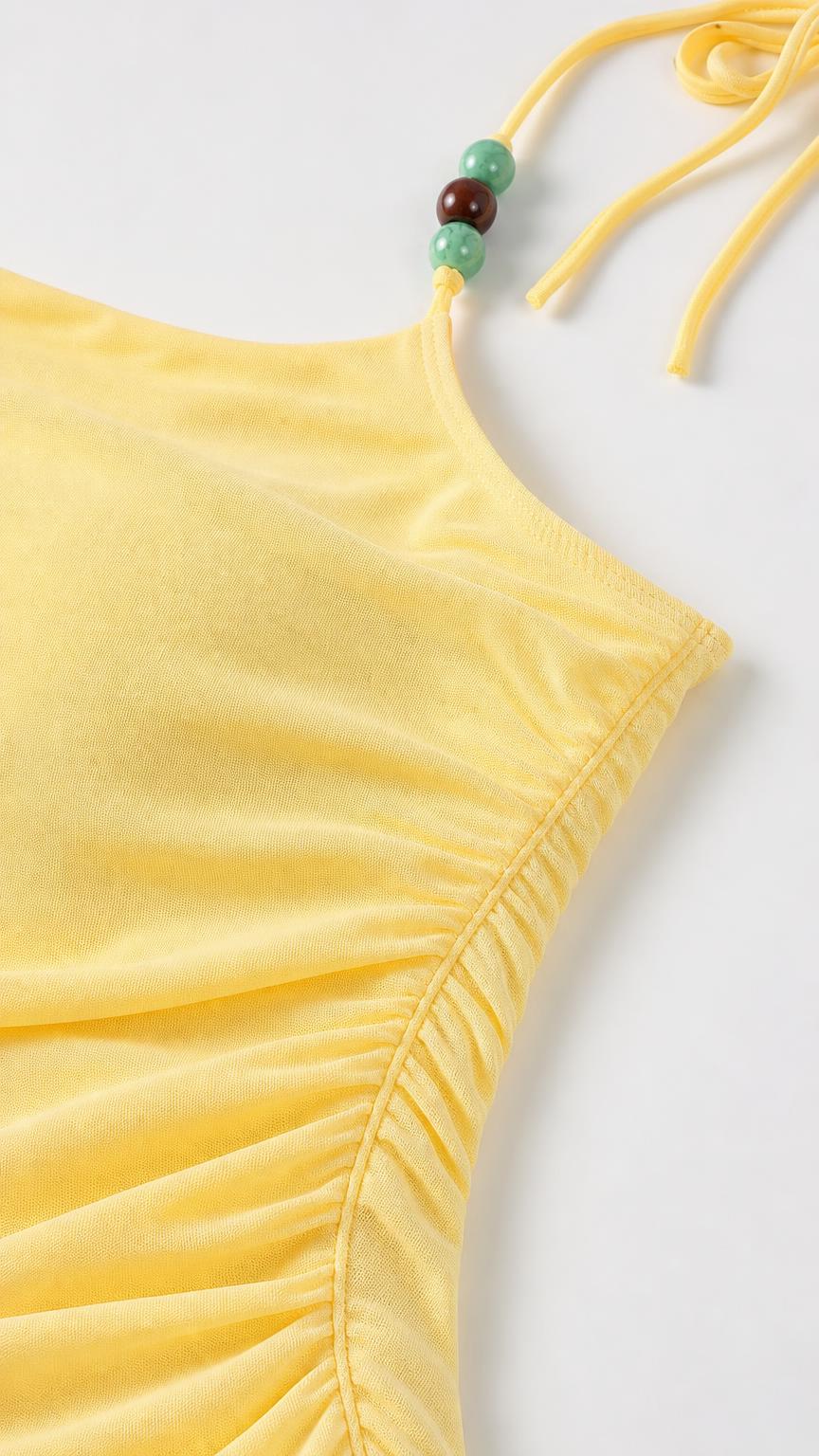 Close-up of yellow cami top with gathered neckline and beaded strap details