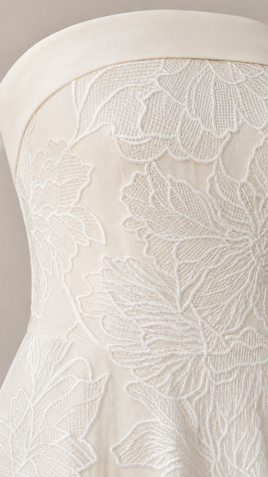 Close-up detail of white floral embroidery on strapless dress bodice