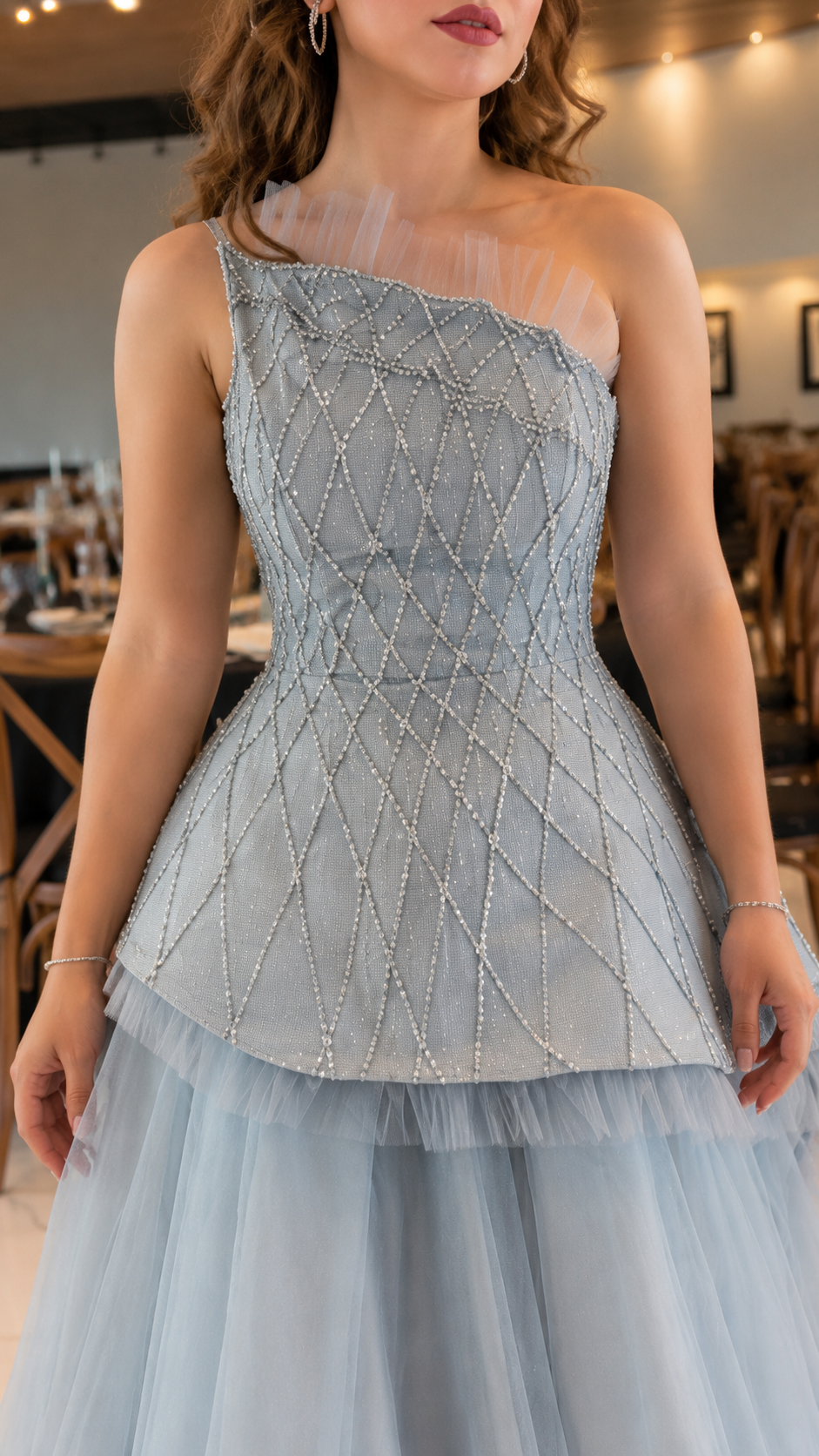 Close-up of dusty blue one-shoulder beaded bodice with sheer mesh neckline detail