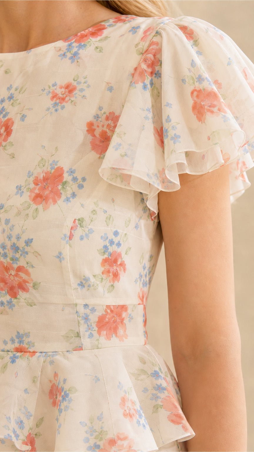Close-up of ruffle sleeves and bodice on cream floral dress