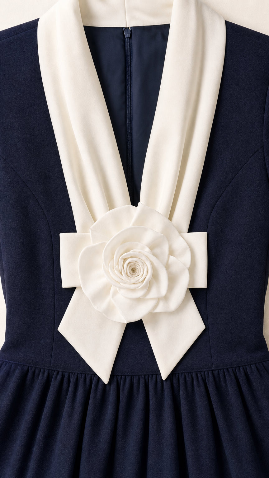 Close-up detail of white collar and fabric rose accent