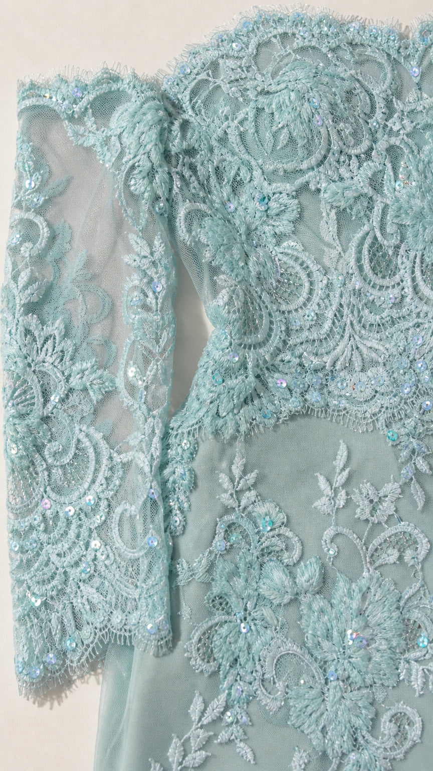 Close-up detail of sheer long sleeves and floral lace texture with beadwork