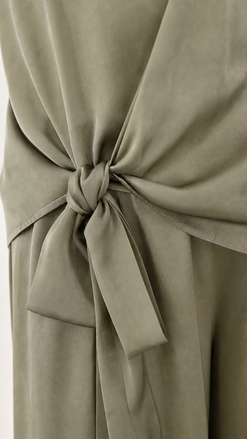 Close up of side tie detail on sage green satin pants