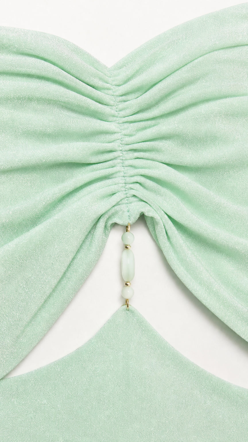 Close-up of ruched bodice and beaded detail on mint green dress