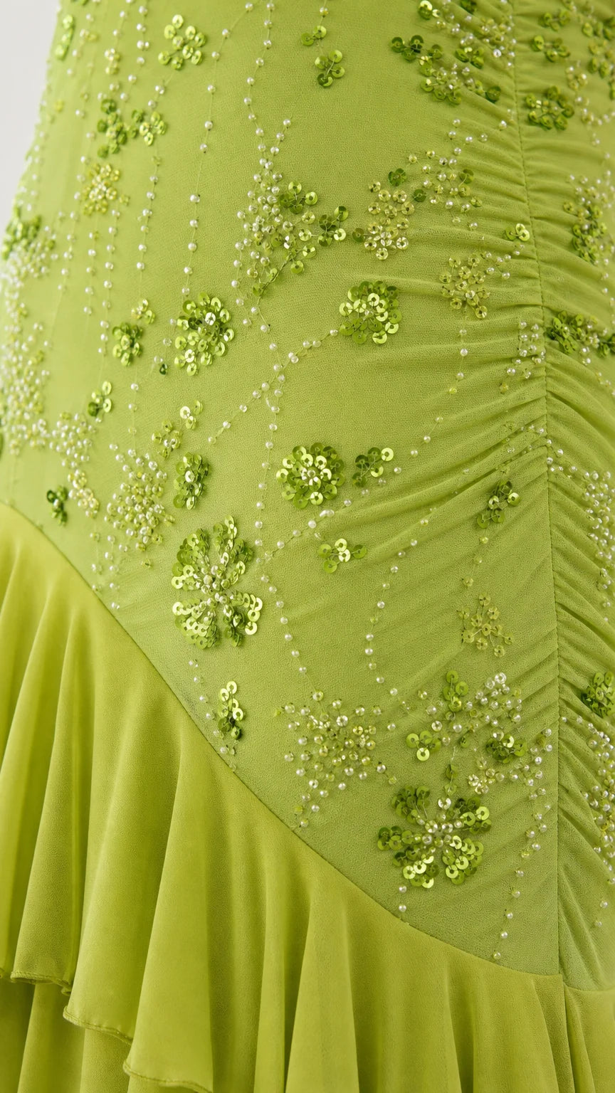Close-up of sequin embroidery and ruffled hem on lime green dress