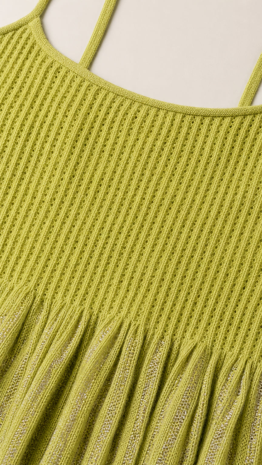 Close-up detail of green knit texture and flounce hem