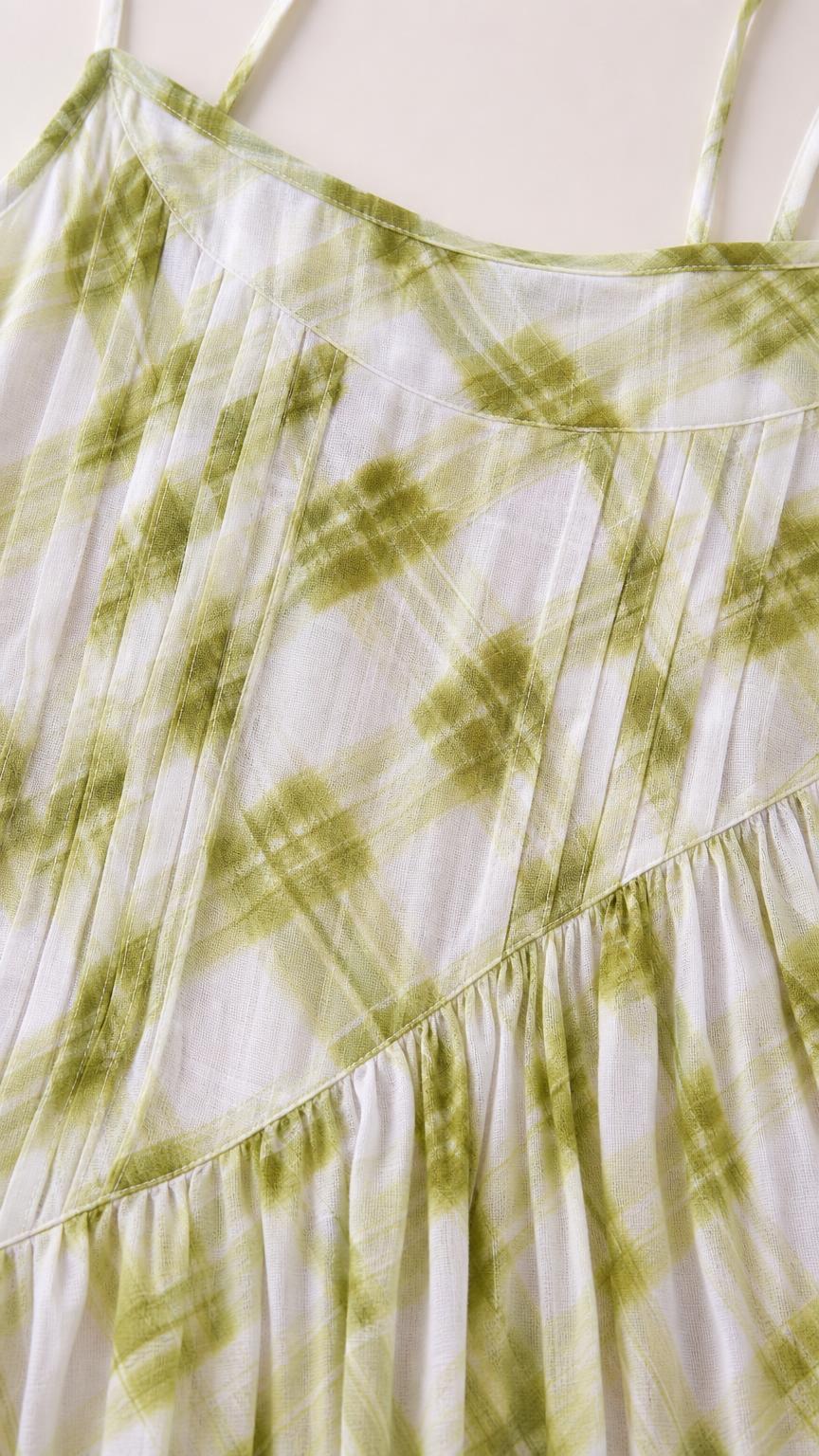 Close-up of fabric texture and pattern on green plaid dress