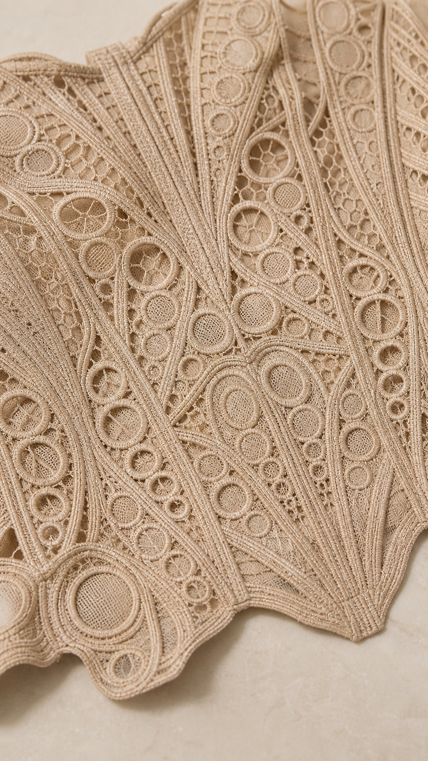 Close up fabric texture view of geometric crochet lace pattern in beige
