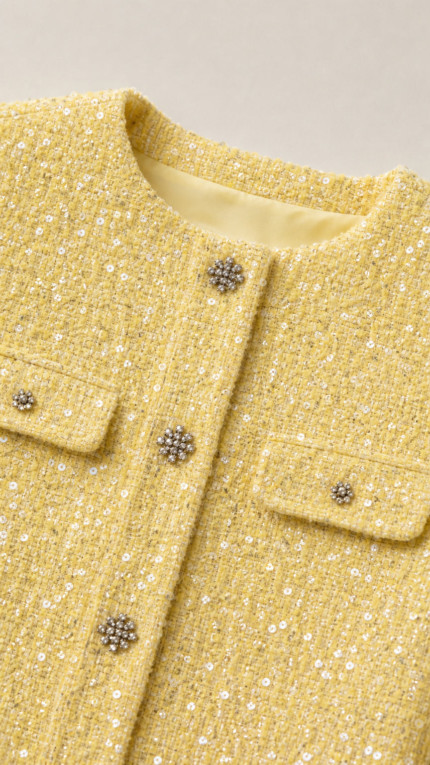Close-up detail of yellow tweed jacket buttons and pocket