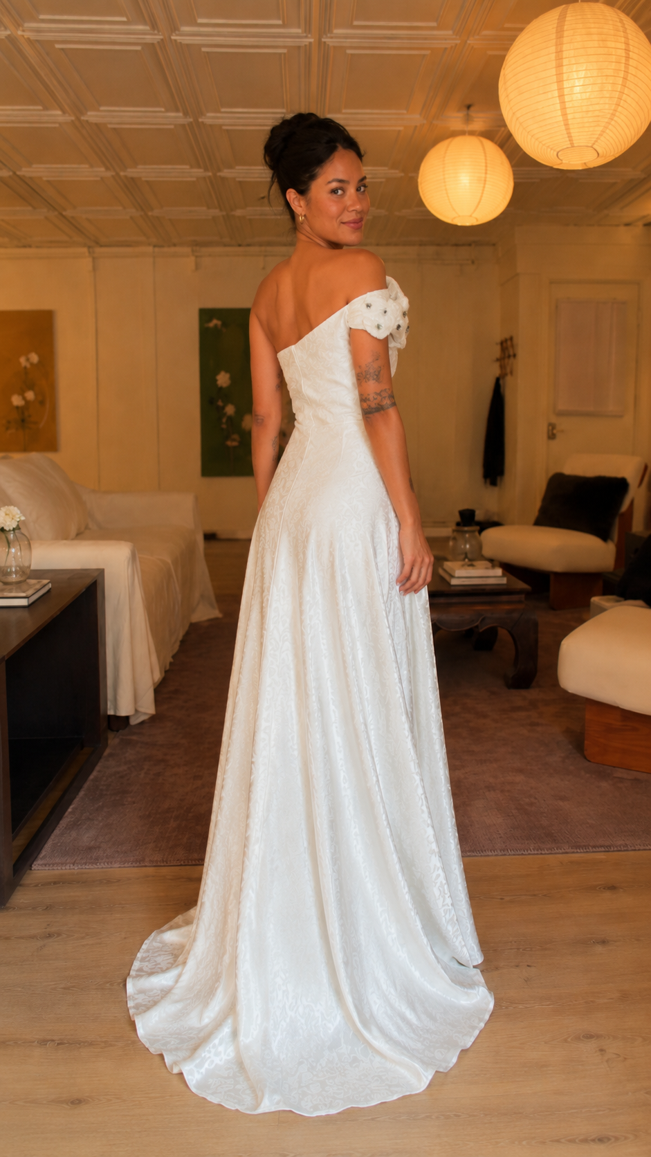 Back view of white one-shoulder maxi gown with flowing skirt