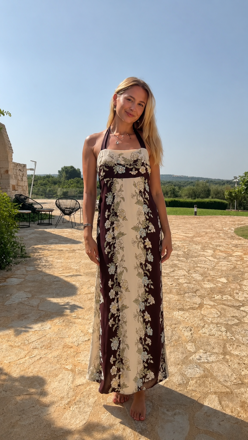 Model wearing chocolate and cream floral halter neck maxi dress full front view