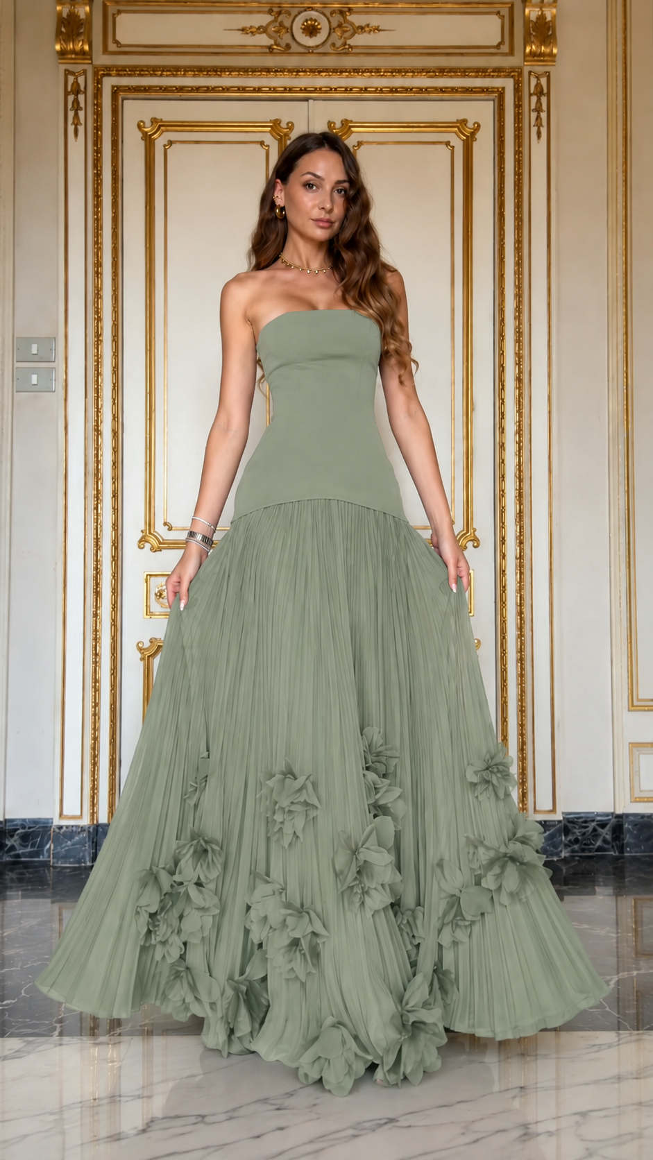 Front view of sage green strapless pleated formal gown with floral hem accents