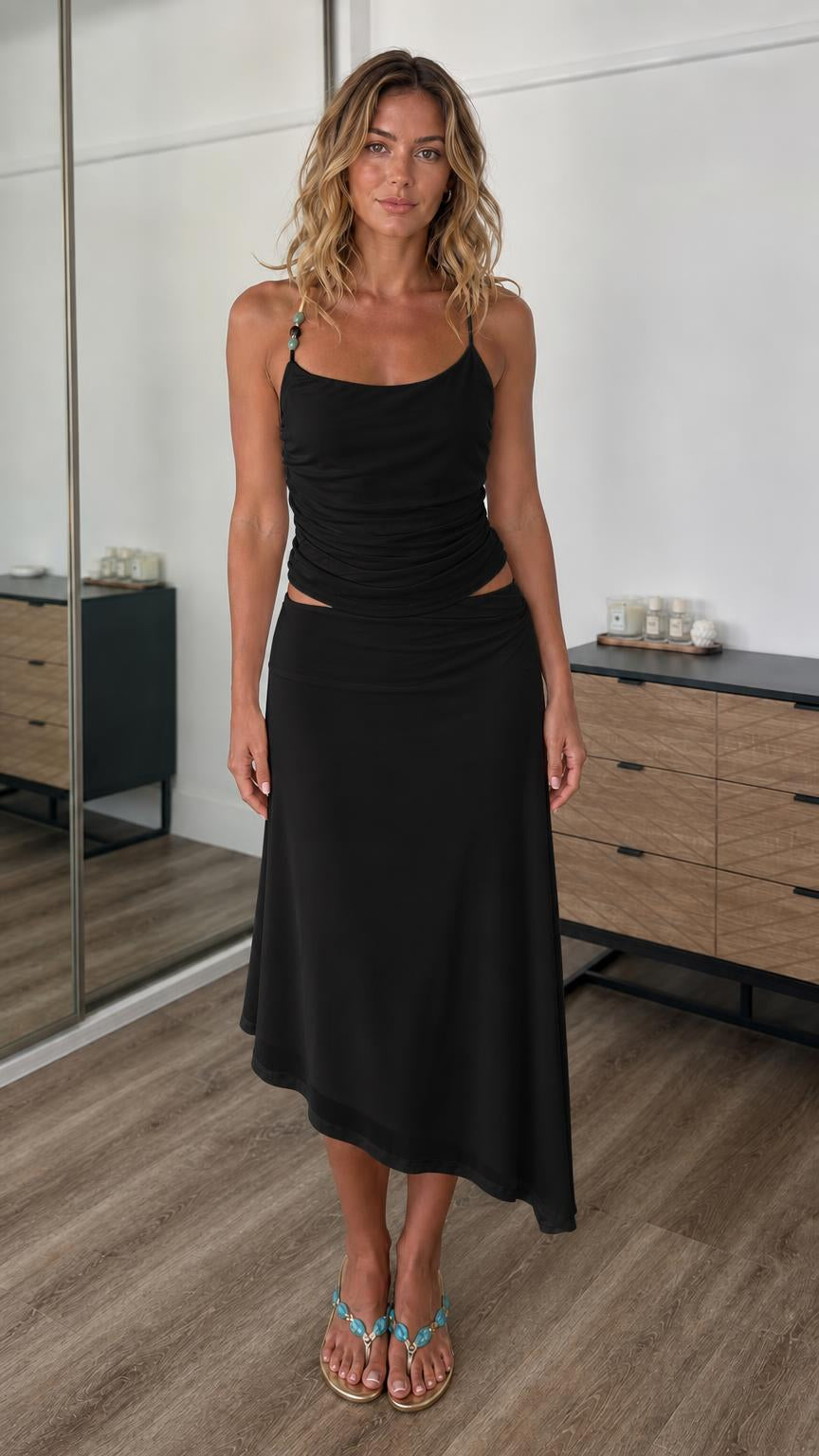Front view of model wearing black two-piece cami top and midi skirt set
