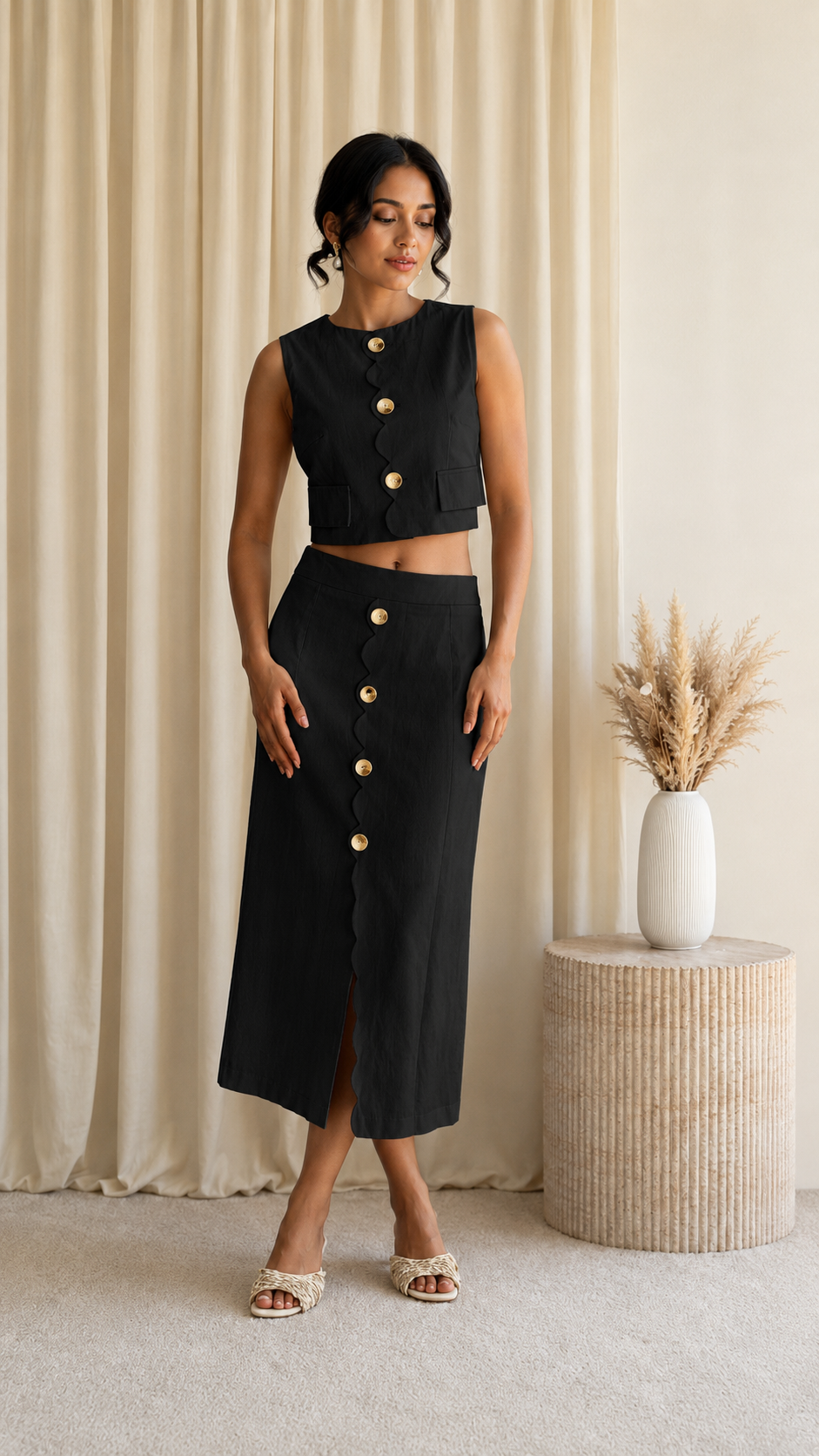 Front view of black sleeveless crop top and button front midi skirt set