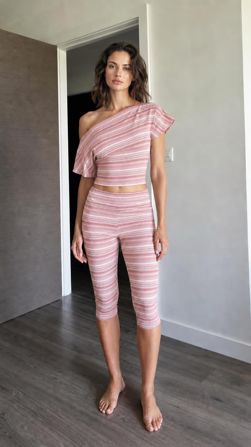 Woman wearing pink striped one-shoulder crop top and capri leggings set