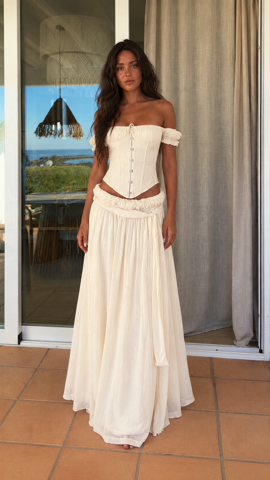 Front view of ivory off shoulder corset top and maxi skirt set