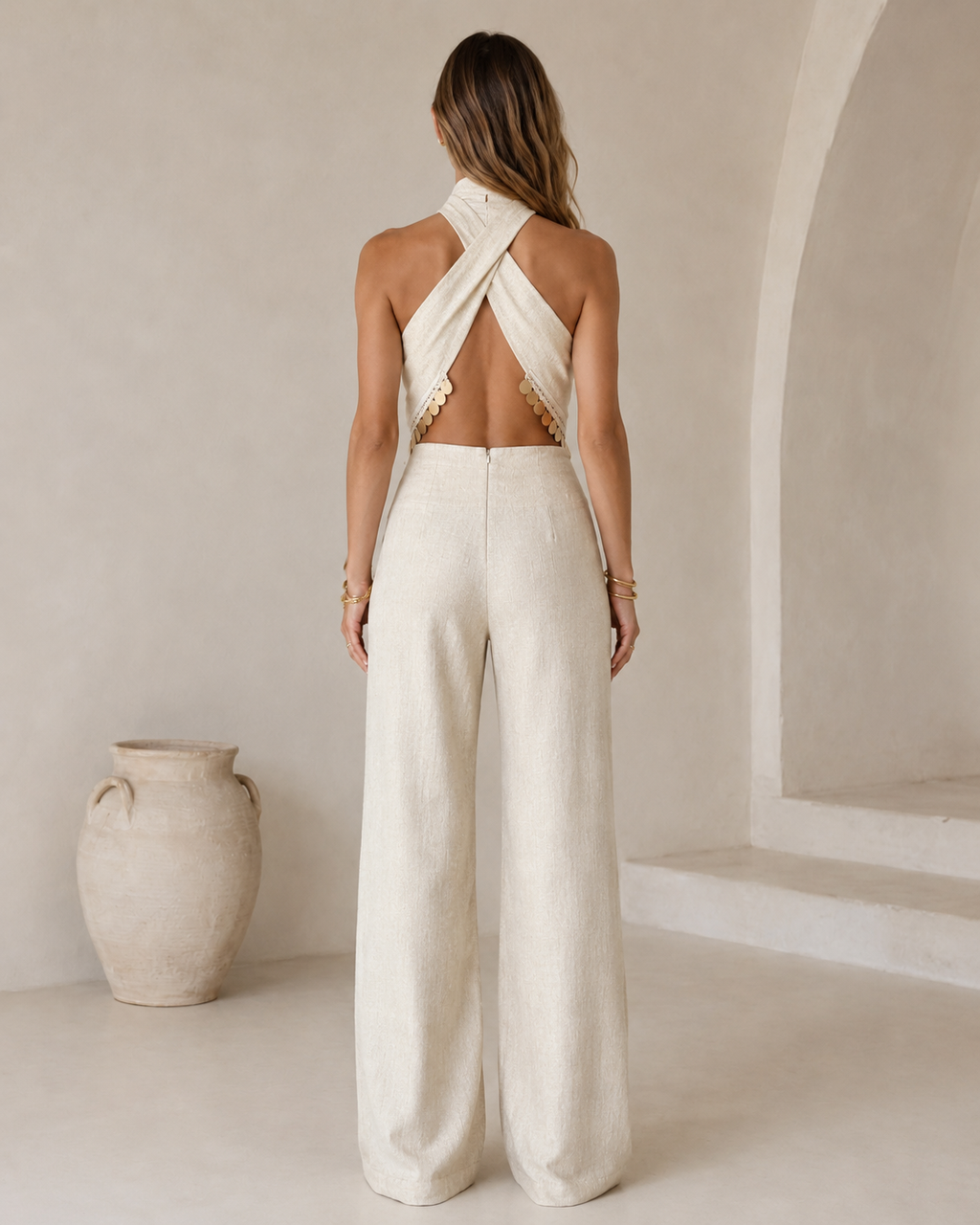 Back view of ivory open-back crossover halter jumpsuit