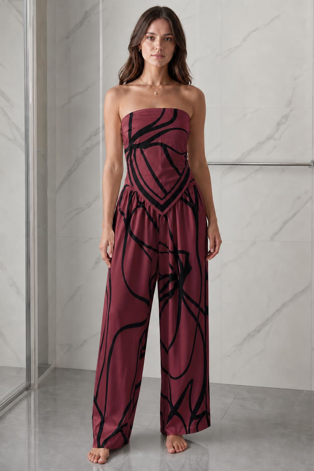 Woman wearing burgundy and black abstract print strapless jumpsuit