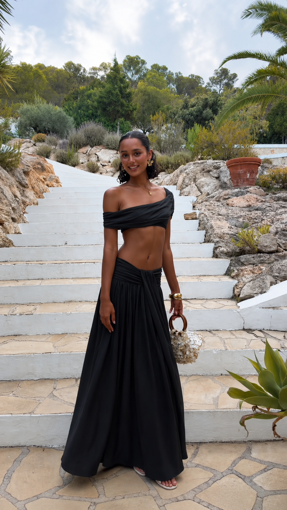 Black off-shoulder two piece set with draped top and flowing floor-length skirt
