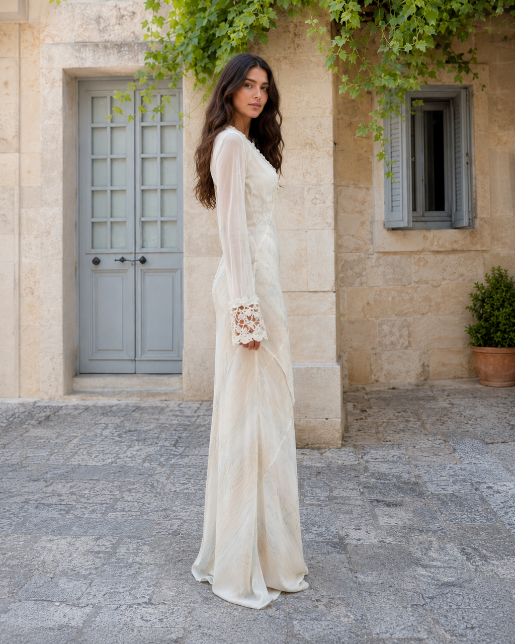 Side view of ivory sheer sleeve lace trim floor-length dress