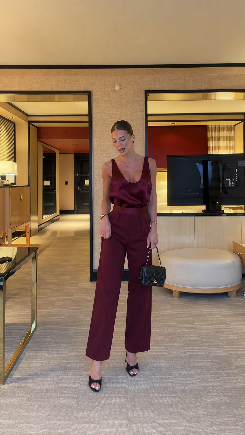 Front view of burgundy satin-look sleeveless jumpsuit with elegant wide leg fit