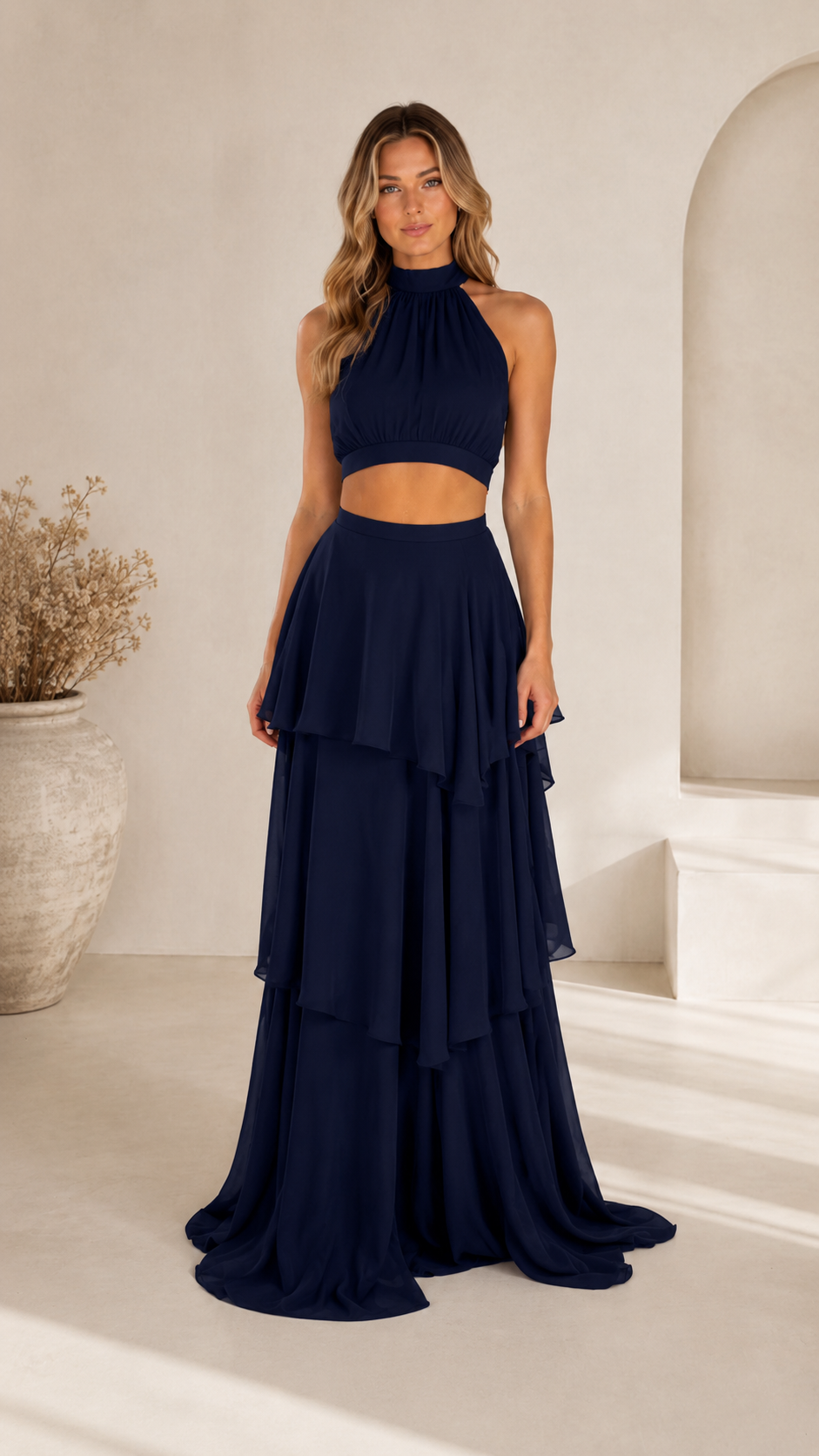 Front view of navy halter crop top and tiered maxi skirt two-piece set